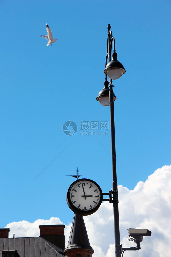 一个灯柱上的闭路电视摄像头和街道钟图片