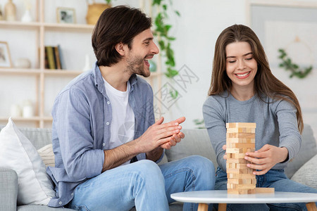 快乐的一对夫妇玩木砖游戏图片