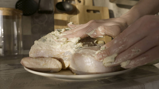 女孩腌生鸡肉在烤箱里做饭关闭女手把绿色的蛋黄酱放在厨房盘图片