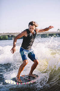 一个人正在一艘摩托艇划过的冲浪板上冲浪背景图片