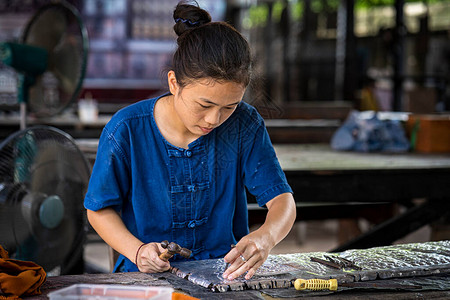 银器制作泰国妇女正在制作银器清迈WuaLai路上的银图片