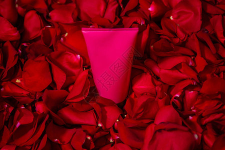 红玫瑰花瓣上的粉色奶油管礼物环保图片