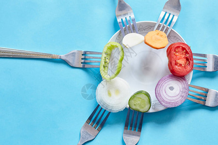 在叉子上切块新鲜蔬菜新鲜的有机洋葱大蒜胡萝卜和甜椒生蔬图片