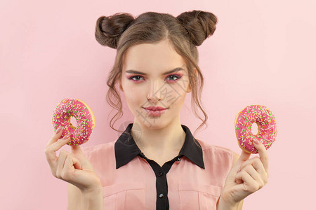 快乐的年轻女人带着甜圈甜图片