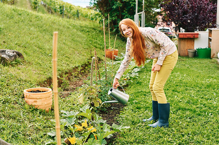 给蔬菜浇水教育儿童照顾花园的少女孩图片