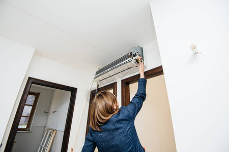 试图修理新安装的空调墙电动器ac单元时进行工程女工程师图片