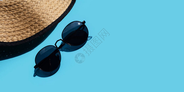 戴着太阳眼镜的帽子蓝底享受暑假概念图片