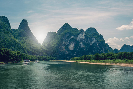 在著名的九马慕拉尔山里程碑峰顶前航行的旅游船图片