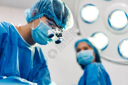 专业麻醉师医生疗团队和助理准备病人进行妇科手术在现代医院手术急诊室使用手术背景图片