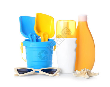 白色背景上带沙滩玩具和太阳镜的防晒霜背景图片