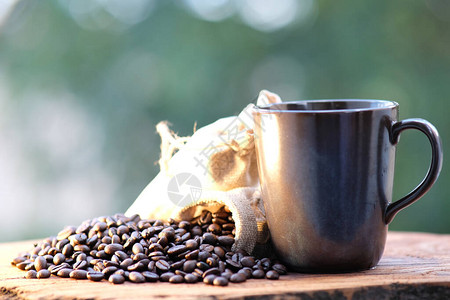 关闭咖啡豆和咖啡杯放在木桌图片