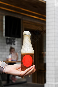 女人手里握着瓶装苏打水的瓶子啤酒泡沫从图片