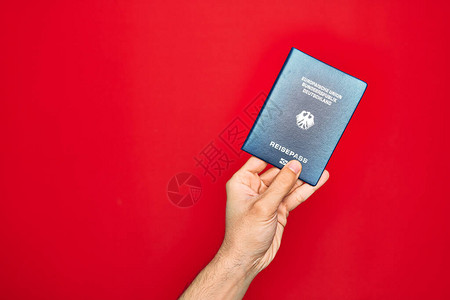 带着德国裔护照身份证明与孤立的红色背景相隔绝图片