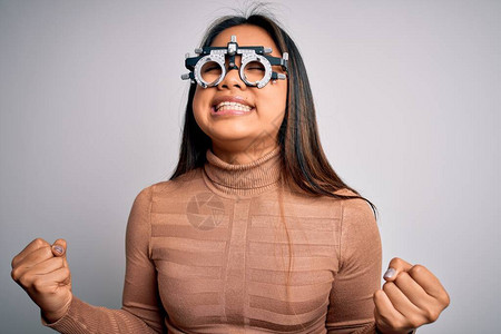 年轻的亚洲光学女孩在白色背景上使用光学眼镜控制视线图片