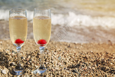 日落时沙滩上香槟杯两杯香槟杯子放图片