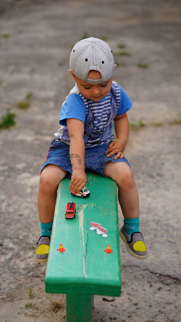 戴帽子玩具车的小可爱男孩在操场的长图片