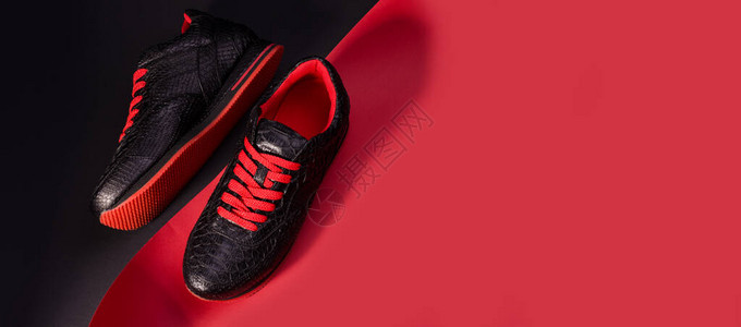 装有蛇皮鞋的时装横幅黑色运动鞋和亮红靴子图片