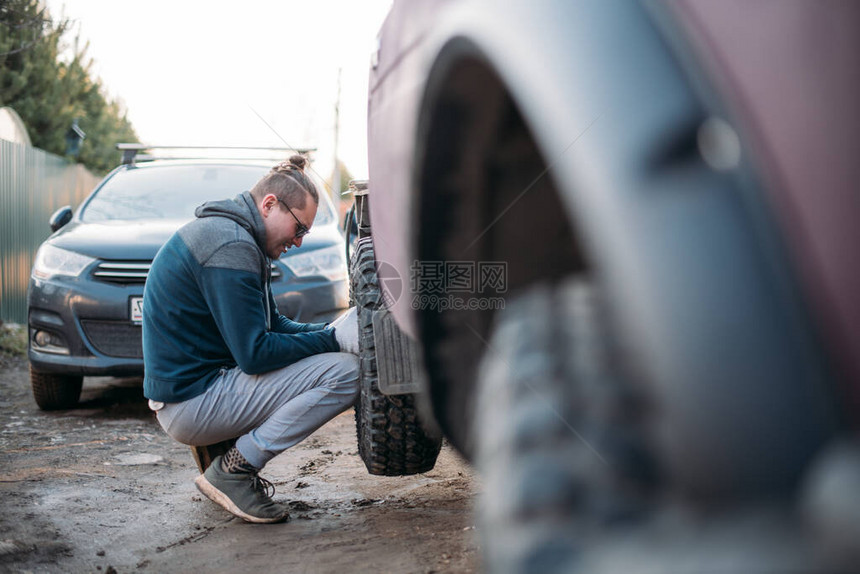 一个男人修车装轮子更换季节轮胎图片