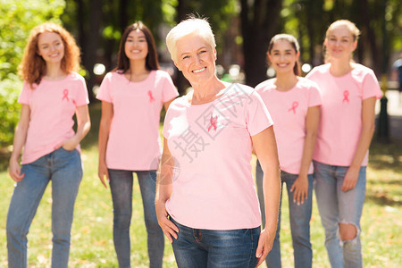 快乐的成熟女人站在公园里与乳腺癌支持小组合影图片