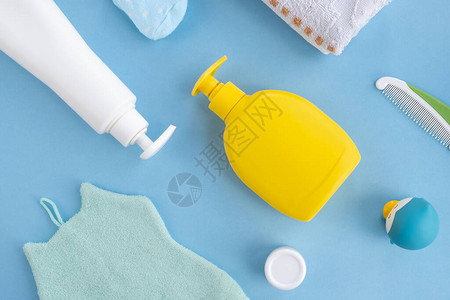 洗发水瓶肥皂奶油梳子袜子毛巾橡胶玩具和浅蓝色背景的海绵图片