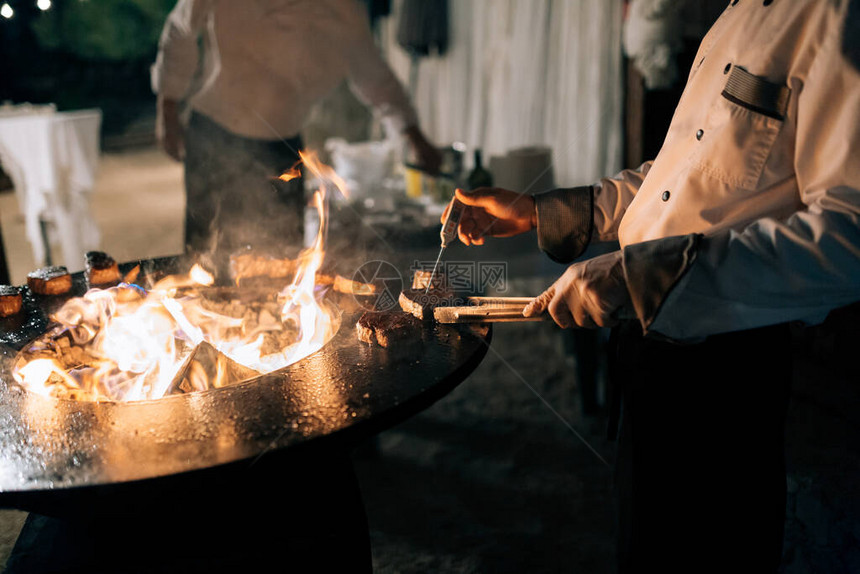 厨师用烤架上温度计测量牛排的温度和烧图片