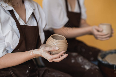 两个女人在陶轮上制作陶器图片