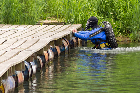 穿着蓝色潜水服的潜水员在河里游泳并清理水库中的碎片艰苦的危险工作假期概念世界环境日和世界水日环背景图片