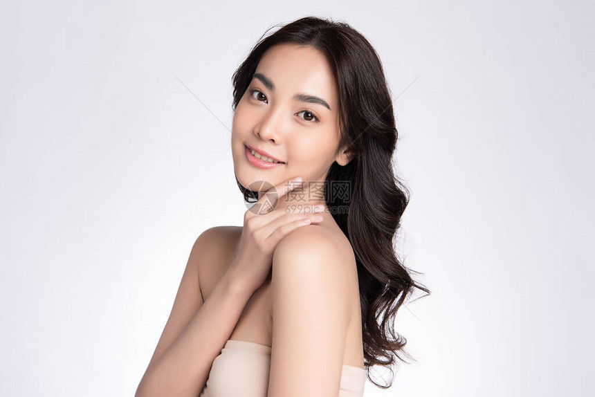 美丽的亚洲年轻女用新鲜健康的皮肤抚摸她干净的脸图片