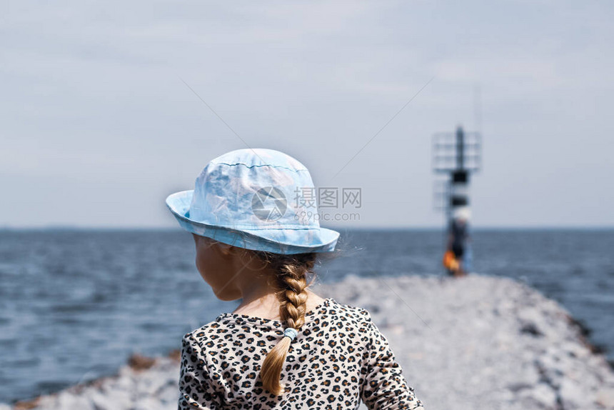 一个背着蓝色巴拿马帽的小女孩图片