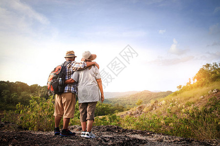 老年夫妇徒步旅行和站在一座高山上在图片