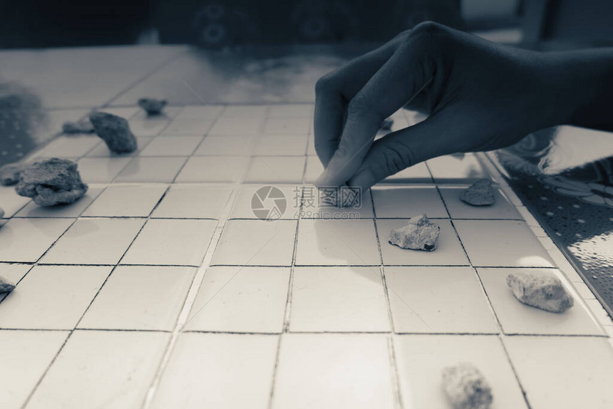 亚洲女人的手捡石头玩跳棋图片