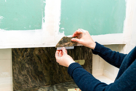 测量铝钢型材如何与天然石材浴室重建相匹配的优雅女建筑师侧视图图片