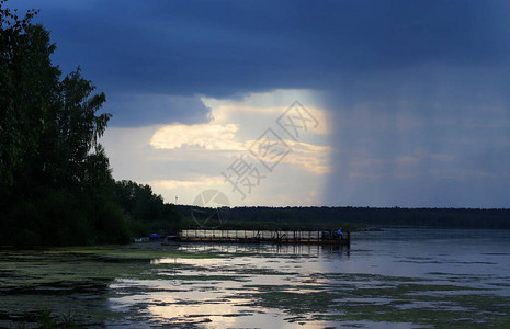 雨前的乌云美丽的灰色天空戏剧天空码头上孤独的渔夫远处的森林之外图片