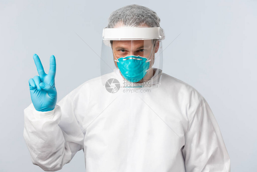 坚定的医生在个人防护设备中与冠状作斗争图片