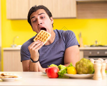 男人在健康饮食和不健康食物之间图片