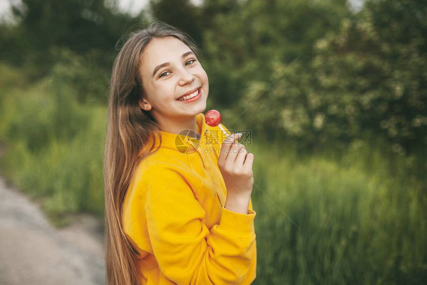 穿着亮黄色毛衣的笑脸女孩拿着鲜图片