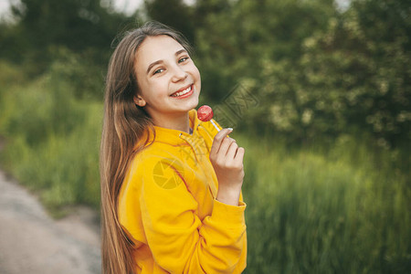 穿着亮黄色毛衣的笑脸女孩拿着鲜背景图片