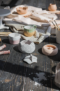 陶艺陶器制作工具刷子和不同陶瓷花瓶和碗在粘土工图片