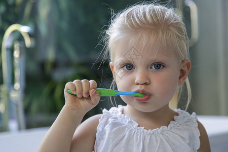 可爱的3岁女孩在浴室刷牙图片