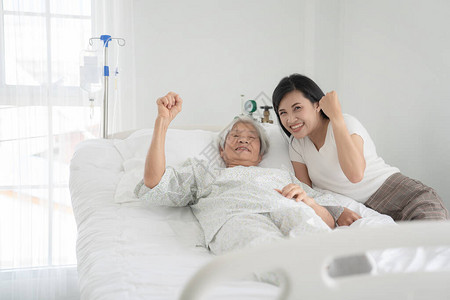 与有病人的祖父和在医院床上握手的图片