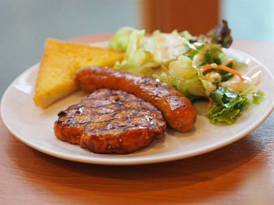 黑辣椒猪肉吐司沙拉蔬菜和香肠在白盘图片