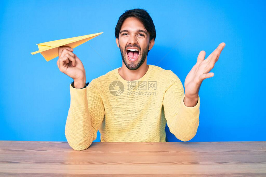拿着纸飞机庆祝胜利的纸机笑和举起手表示优胜者图片