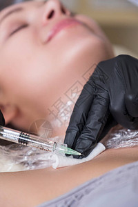 美容科医生在诊所里对一名妇女进行注射手术图片
