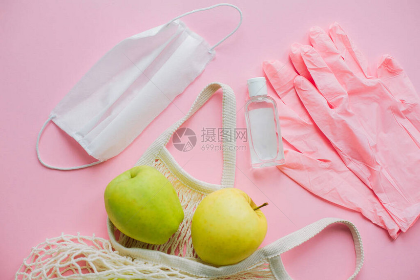 粉红色的手套面罩消毒瓶和手提袋图片