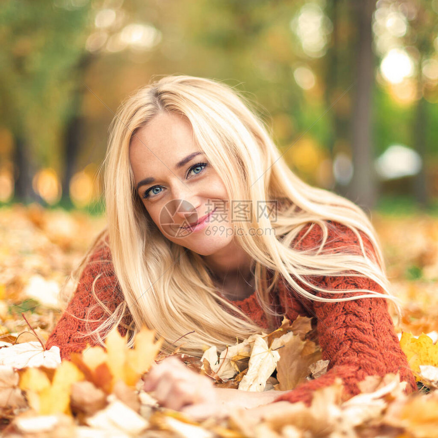 美丽的年轻金发美女白头发花脸女人躺在秋天图片