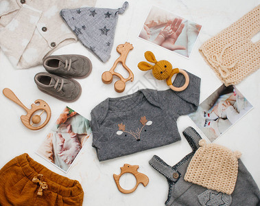 婴儿淋浴概念新生儿婴服装木玩具和白色大理石背景的婴儿照片图片
