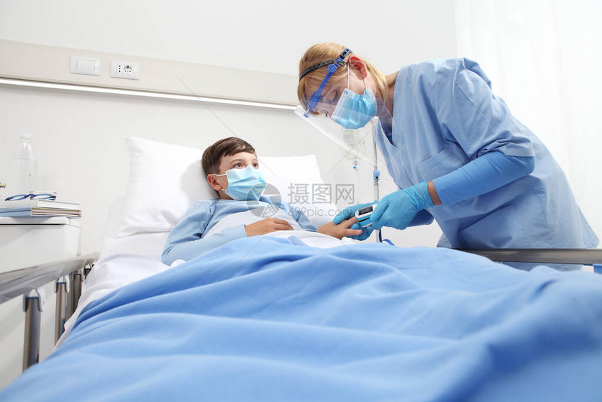 护士在病床上给病人的孩子带脉搏血氧仪图片