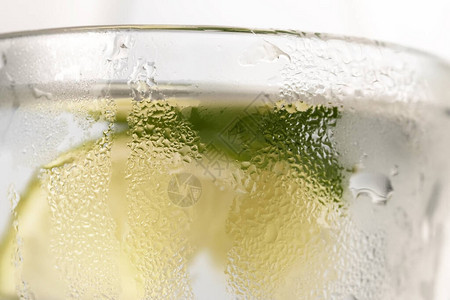 在透明的汗水玻璃杯中放上柠檬片和冰块的清爽柠檬水图片
