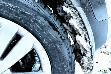 雪粘在车轮和保险杠上寒冷天气的开始图片