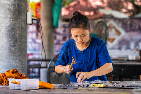 银器制作泰国工匠正在制作银器清迈WuaLai路上的银图片